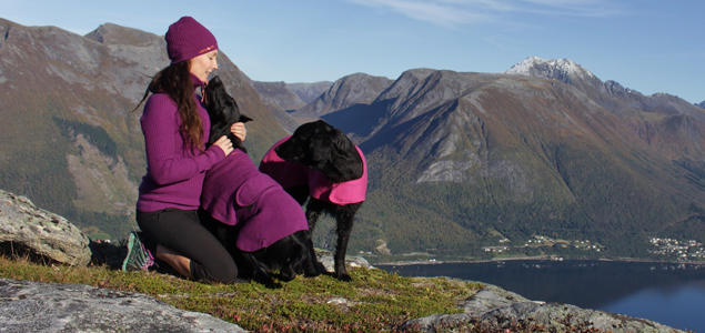 Foto: Lill-Iren Høiland Kvinne med hunder på fjellet, med usikt utover fjorden